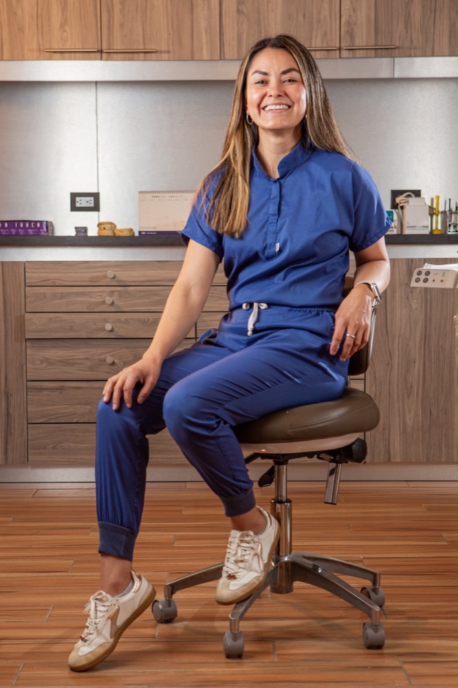 La fundadora de Dra. Li sonriendo en su consultorio, con un uniforme azul
